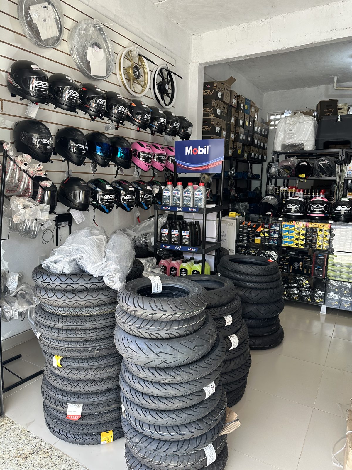 Interior da loja com pneus, óleos e acessórios para motos
